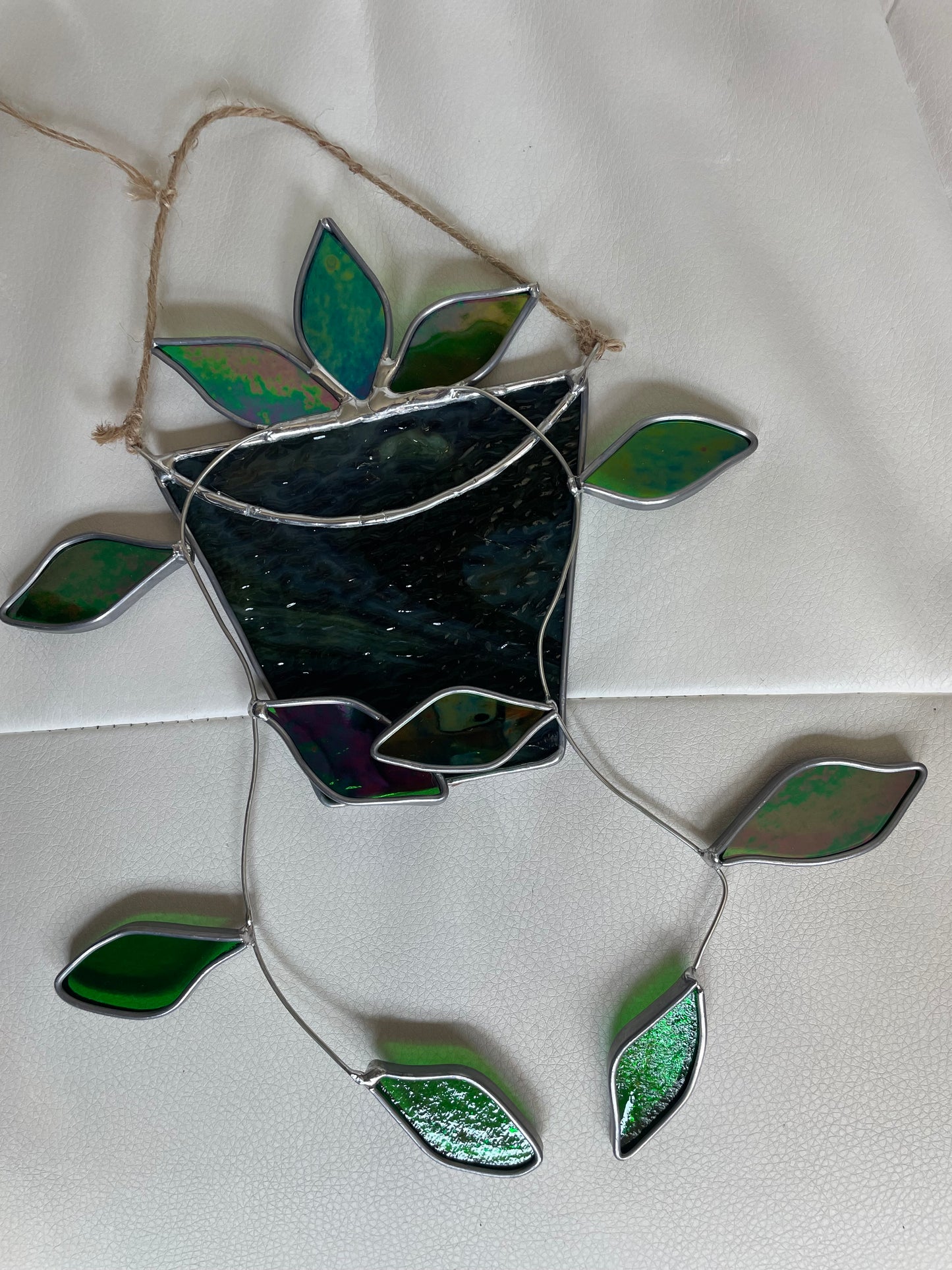 Hanging pothos in a green and brown pot